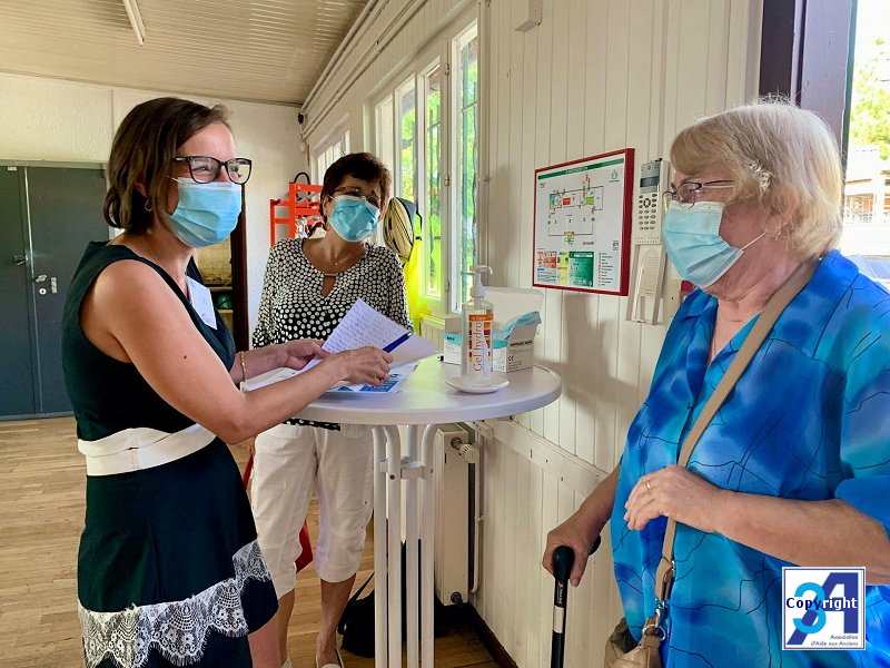 Mme Marie Tricot (coordinatrice-animatrice) et Doris (bénévole) qui accueillent les personnes afin de dresser la liste de personnes présentes, ici Suzy (bénévole). Masques et gel hydroalcoolique obligatoires. 03.jpg